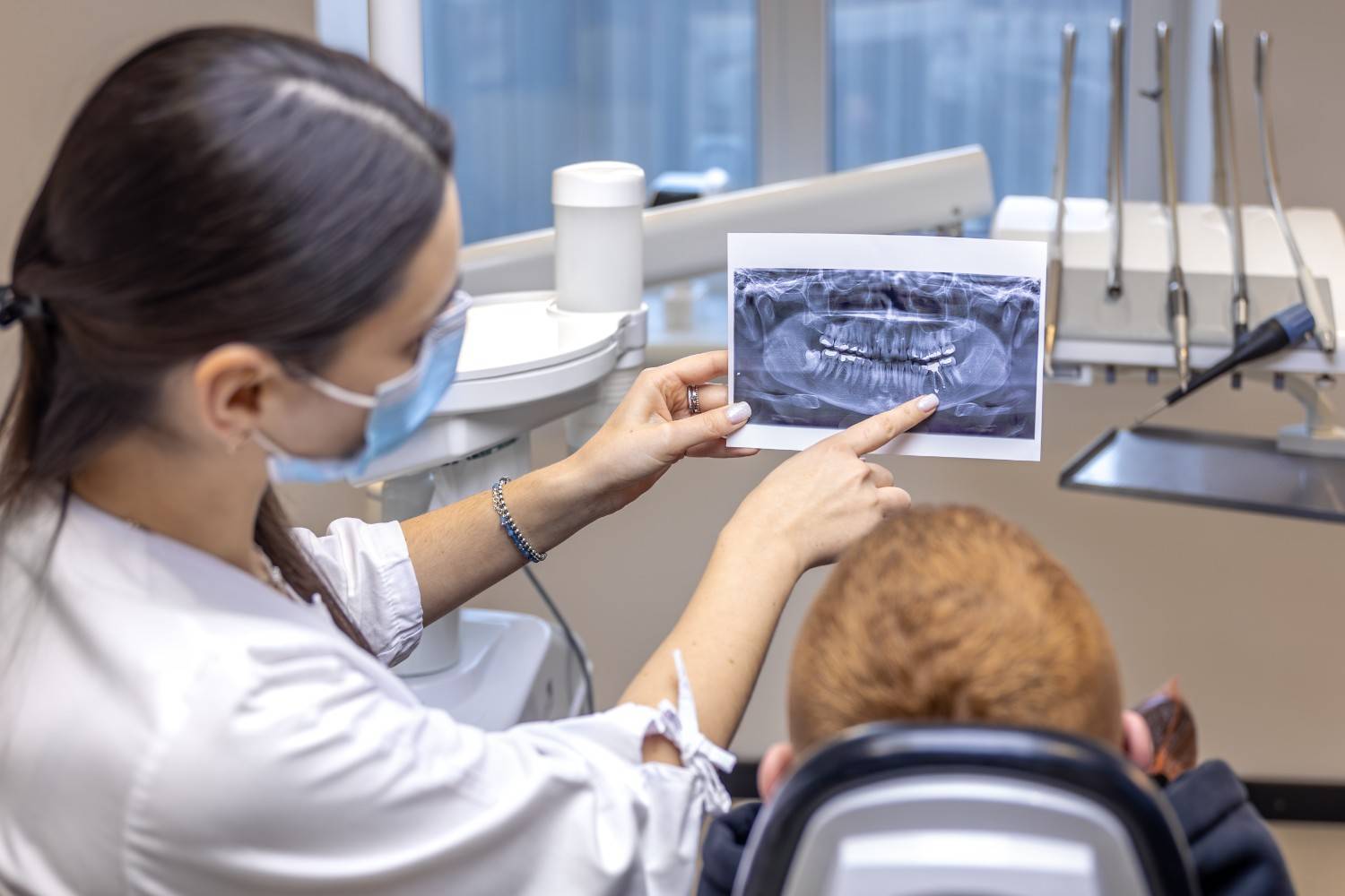 Dentist showing dental X-ray for Invisalign consultation